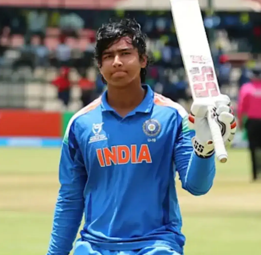 This image features the 14-year-old Indian teenage sensation Vaibhav Sooryavanshi celebrating a historic achievement. He is shown wearing the India Under-19 blue jersey, raising his bat in triumph after scoring a record-breaking 175 runs off 80 balls in the ICC Under-19 World Cup final against England on February 6, 2026. The background likely shows the Harare Sports Club where India secured its record sixth U19 World Cup title.